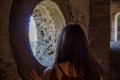 Rear view of woman standing at archway