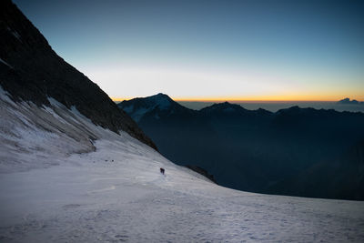 Scenic view of snowcapped mountains against sky during sunset