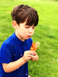 Full length of boy holding grass