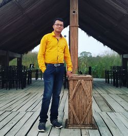 Portrait of young man standing against wall