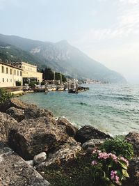 Scenic view of sea by buildings against sky