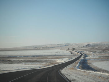 Empty road along countryside landscape