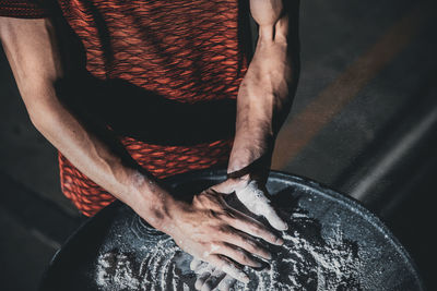 Midsection of man rubbing talcum powder in gym