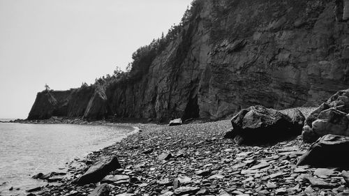 Rock formations by sea against sky