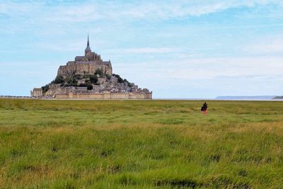 Woman standing on field against sky