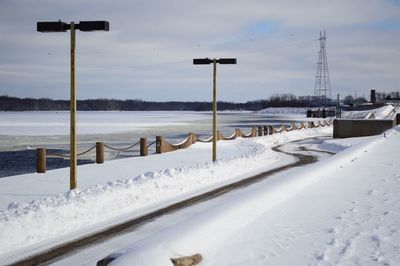 Snow covered road along lake