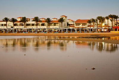 Scenic view of lake by buildings against sky