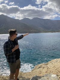 Man standing by sea against sky