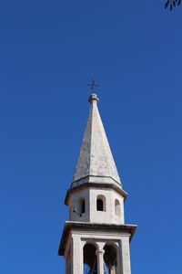 Low angle view of bell tower against blue sky