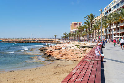 Panoramic view of people on beach against clear sky