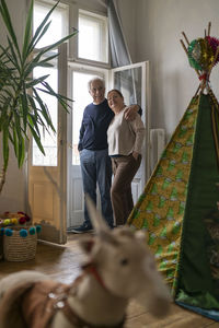 Senior couple standing at the window in children's room