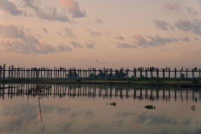 Pier over sea against sky during sunset