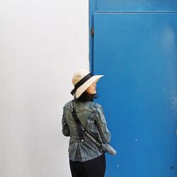 Rear view of woman standing against wall