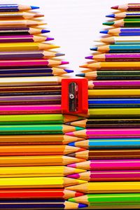 Close-up of sharpener on multi colored pencils over white background