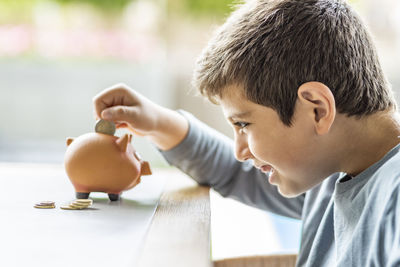 Portrait of boy holding ice cream on table