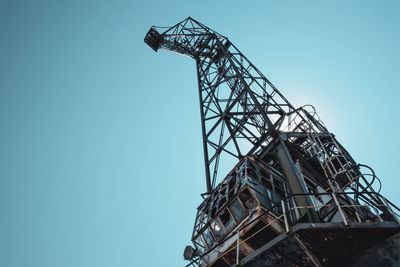 Low angle view of crane against clear blue sky