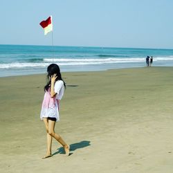 Woman on beach against sky