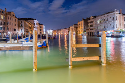 Boats in canal amidst buildings in city