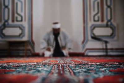 Surface level of man sitting on carpet