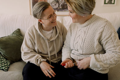 Happy lesbian couple looking at each other while doing ivf test