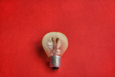 High angle view of light bulb against red background