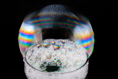 Close-up of bubbles over black background