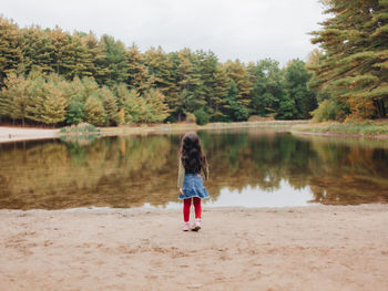 Girl playing by lake on a lovely autumn or fall day