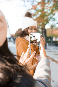 Best friends taking pictures in the park with their cell phones