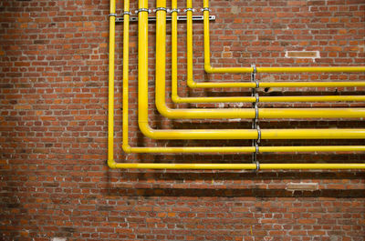 Yellow pipeline against brick wall