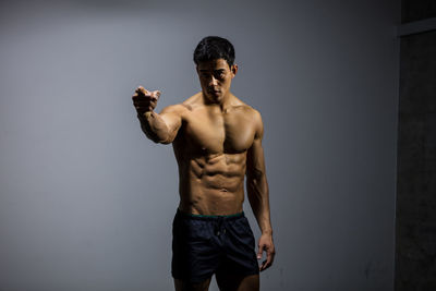 Man standing with muscular build over gray background