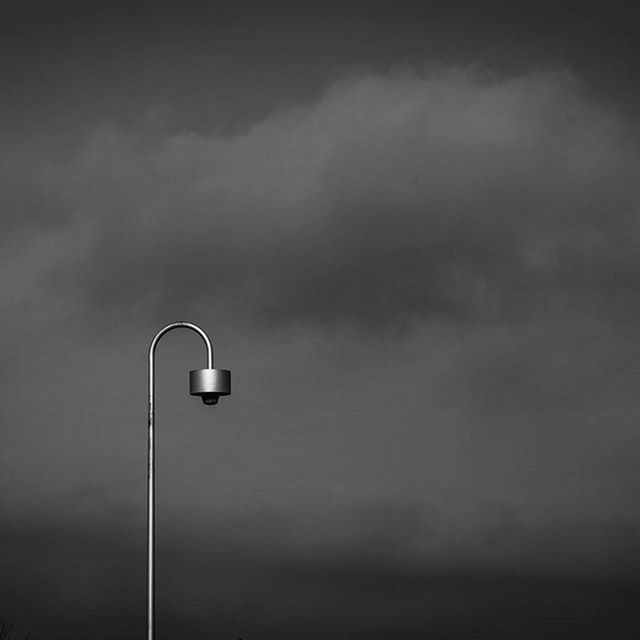 low angle view, sky, street light, lighting equipment, cloud - sky, cloudy, cloud, dusk, pole, no people, outdoors, electricity, built structure, electric light, overcast, silhouette, copy space, high section, day, architecture