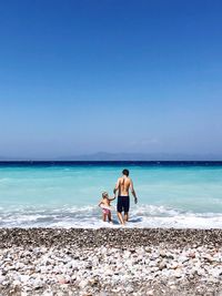 Friends on beach against clear sky