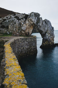 Rock formations by sea against sky