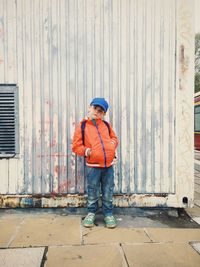 Portrait of boy standing against wall 