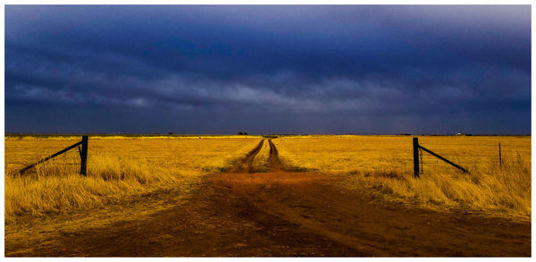 Wooden fence on field against sky