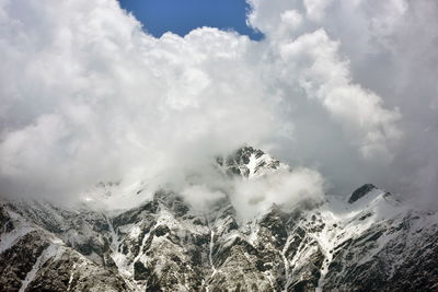 Low angle view of snowcapped mountains against sky