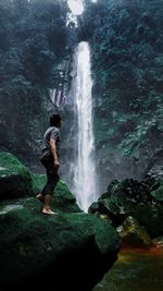 Full length of waterfall on rocks in forest