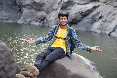 Portrait of man sitting on rock