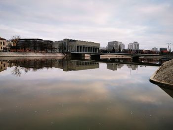 Reflection of buildings in river against sky