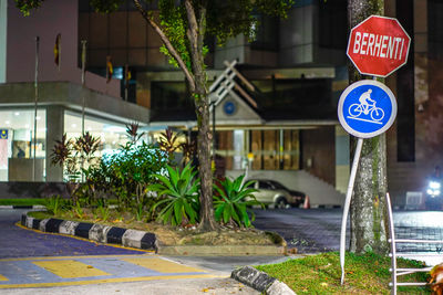 Road sign by street against buildings in city