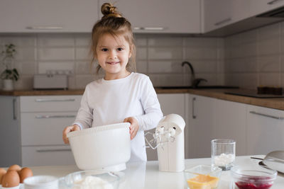 Portrait of cute baby girl sitting at home