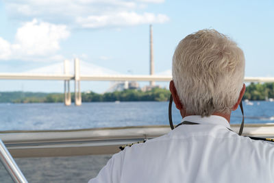 Rear view of man looking at sea against sky