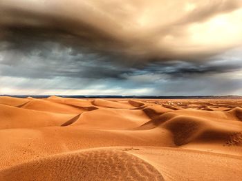 Sand dunes in desert against sky