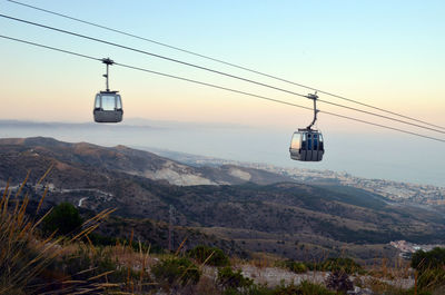 Overhead cable car on mountain against sky