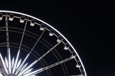 Low angle view of illuminated ferris wheel against sky at night