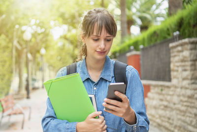Young woman using mobile phone outdoors