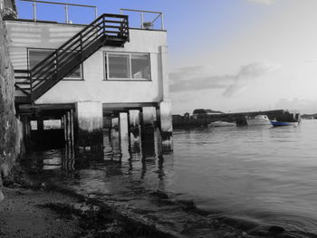 Abandoned building by sea against sky