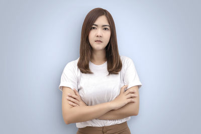 Portrait of beautiful young woman against white background
