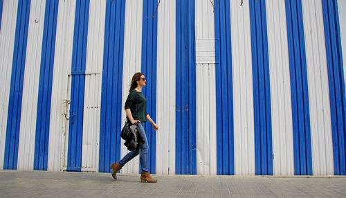 Woman standing against blue wall