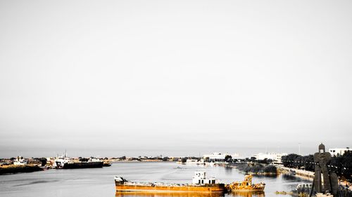 View of city at waterfront against clear sky